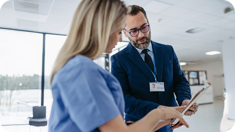 Man holding a clipboard while talking to a woman Man holding a clipboard while talking to a woman